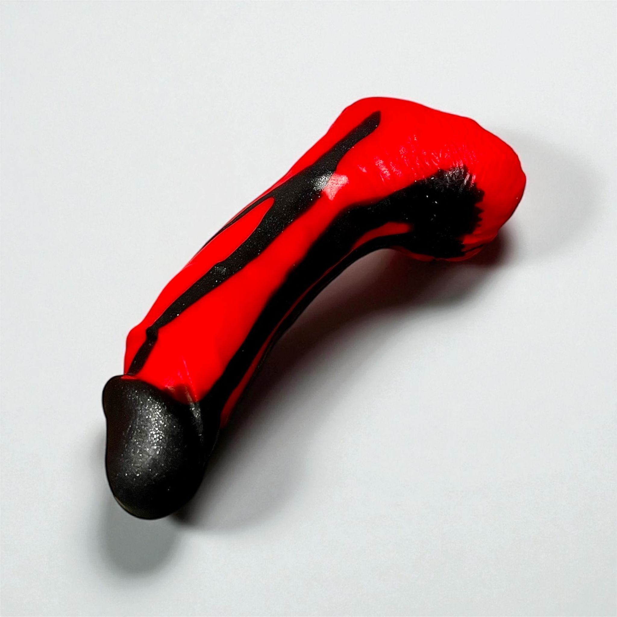 Gode Kamoulox en silicone bi-ton rouge et noir, posé à plat – You & Me FrenchToys